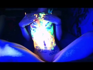 Petite flatchested  girl painting herself with blacklight paint 