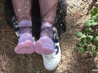 Cute Soles And Toes Wiggling In White Nylon Socks In The Forest