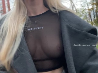 A girl shows her breasts while walking around city