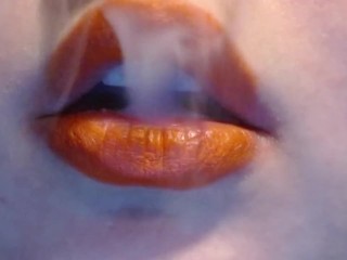 Smoking With Orange Lips and a wicked smirk