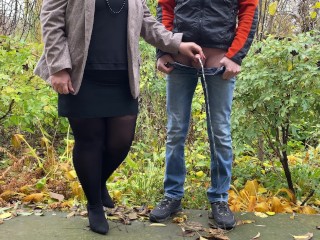 Hot milf in pantyhose and skirt holding guy's cock outdoors while pissing