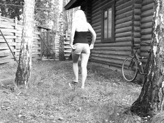 Slim big booty MILF peeing in a secluded outdoor spot.