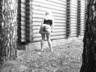 Slim big booty MILF peeing in a secluded outdoor spot.