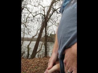 Ginger pissing outdoors at the river