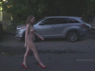 Naked woman walking on the city street in the early morning. Public