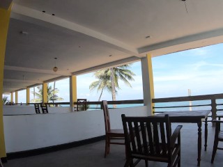 Naked girl walks on the balcony overlooking the ocean