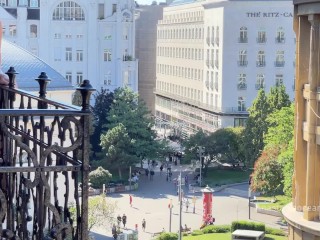 A woman undresses on a balcony in the city center. Public flashing.