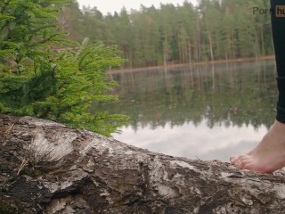 A girl in nature took off her boots and shows her bare feet