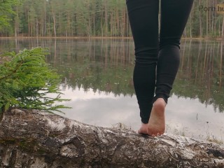 A girl in nature took off her boots and shows her bare feet