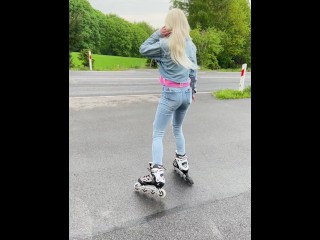 A rollerblade blondie girl is littering and smoking and spitting loogies while smoking a cigarillo