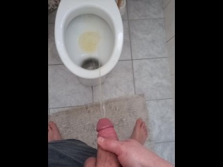 Big and hard cock of a young guy gives out a golden shower in the morning