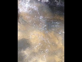 Country Girl Crawling On Her Hands and Knees In Water At Popular Spring Creek Collecting Rocks