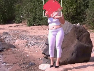 Girl with big ass in white leggings on the coast