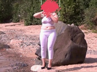 Girl with big ass in white leggings on the coast