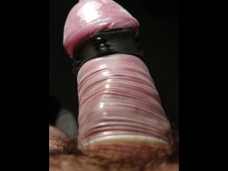 Close up POV of vibrating penis in slow motion while wearing condom