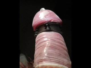 Close up POV of vibrating penis in slow motion while wearing condom