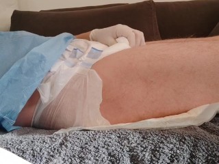 Urinating in a diaper with an inserted catheter after filling the bladder, relaxing...