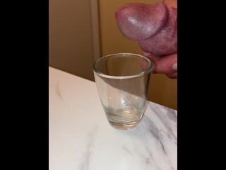 Collecting my cum in a shot glass, breathing heavy and moaning squeezing it out of my dick