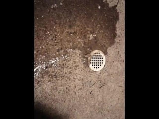 Pissing by a drain on the sidewalk