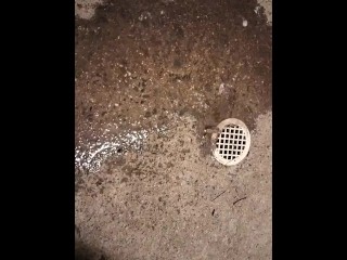 Pissing by a drain on the sidewalk