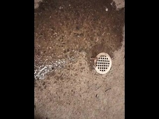 Pissing by a drain on the sidewalk