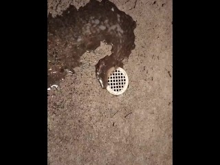 Pissing by a drain on the sidewalk