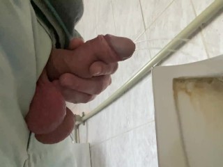 A guy pisses in a public office toilet. POV 4K