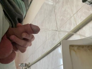 A guy pisses in a public office toilet. POV 4K