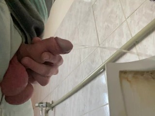 A guy pisses in a public office toilet. POV 4K
