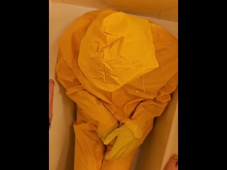 Pissing over  yellow rainwear with yellow gloves and latex mask