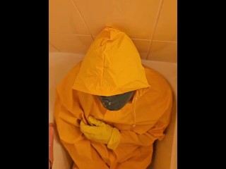 Pissing over  yellow rainwear with yellow gloves and latex mask