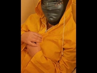 Pissing over  yellow rainwear with yellow gloves and latex mask