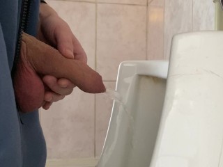 A guy pisses in a public urinal from an uncut penis without opening it 4K