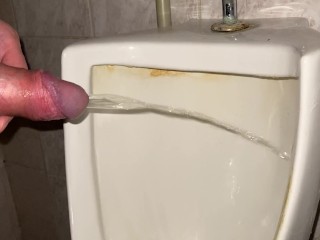 Quick pissing in a public toilet close up