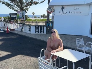 girl sitting naked in a cafe in public