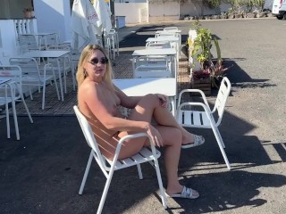 girl sitting naked in a cafe in public