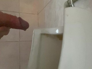 Pissing with a big dick with big balls in a public toilet in a urinal
