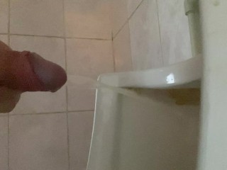 Pissing with a big dick with big balls in a public toilet in a urinal
